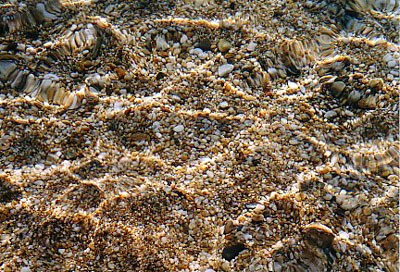 Agios Isidoros, Kieselsteine im flachen Wasser